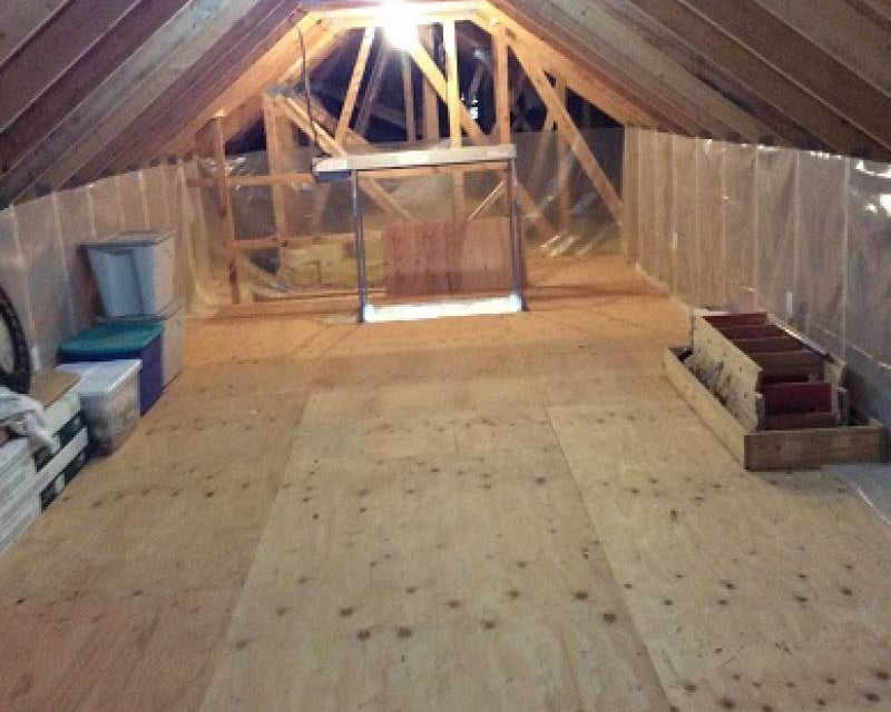 Interior of a clean attic with an attic lift in the distance