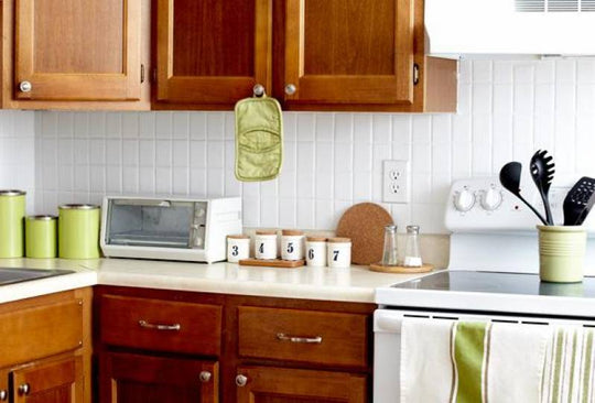 Crisp and clean counter tops and cabinets in a green, white and brown kitchen.