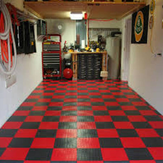 Overview of a black and red checked garage floor with tools and storage in the background.